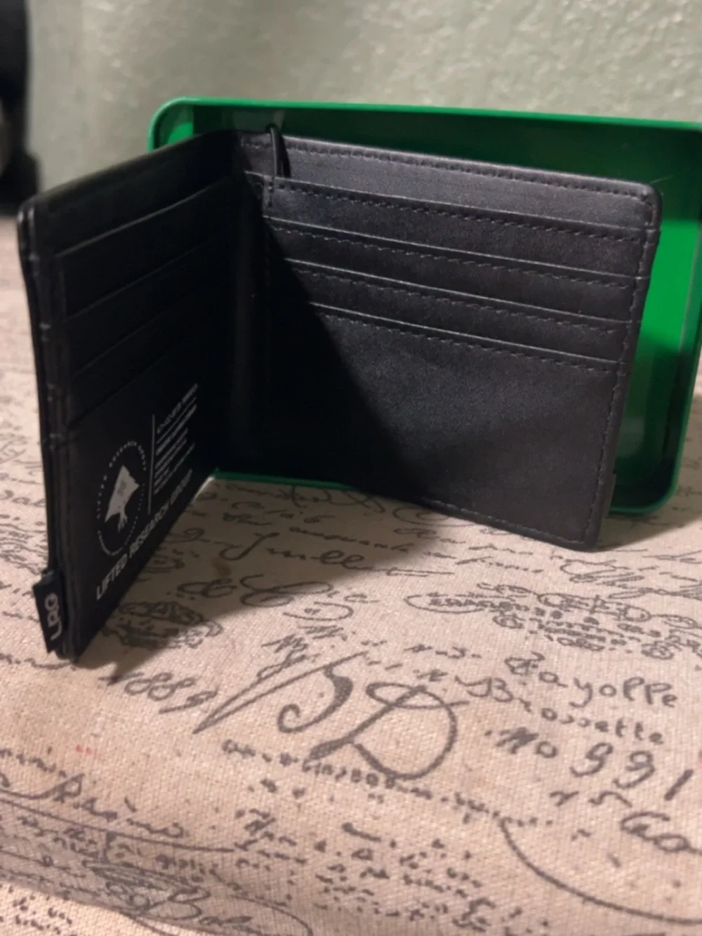 LRG Lifted Research Group black bifold wallet comes in a green branded tin